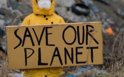 Save Our Planet Sign held by child in front of landfill