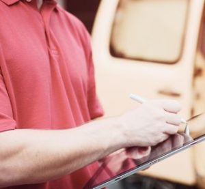Delivery person signing digital tablet